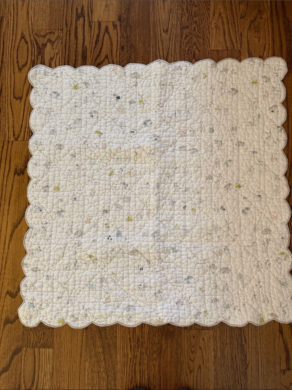 Pristine Petit Pehr White Scalloped Quilted Baby Blanket with woodland creatures